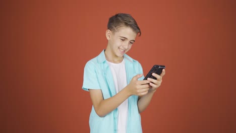 Happy-boy-texting-on-the-phone.-Smiling.